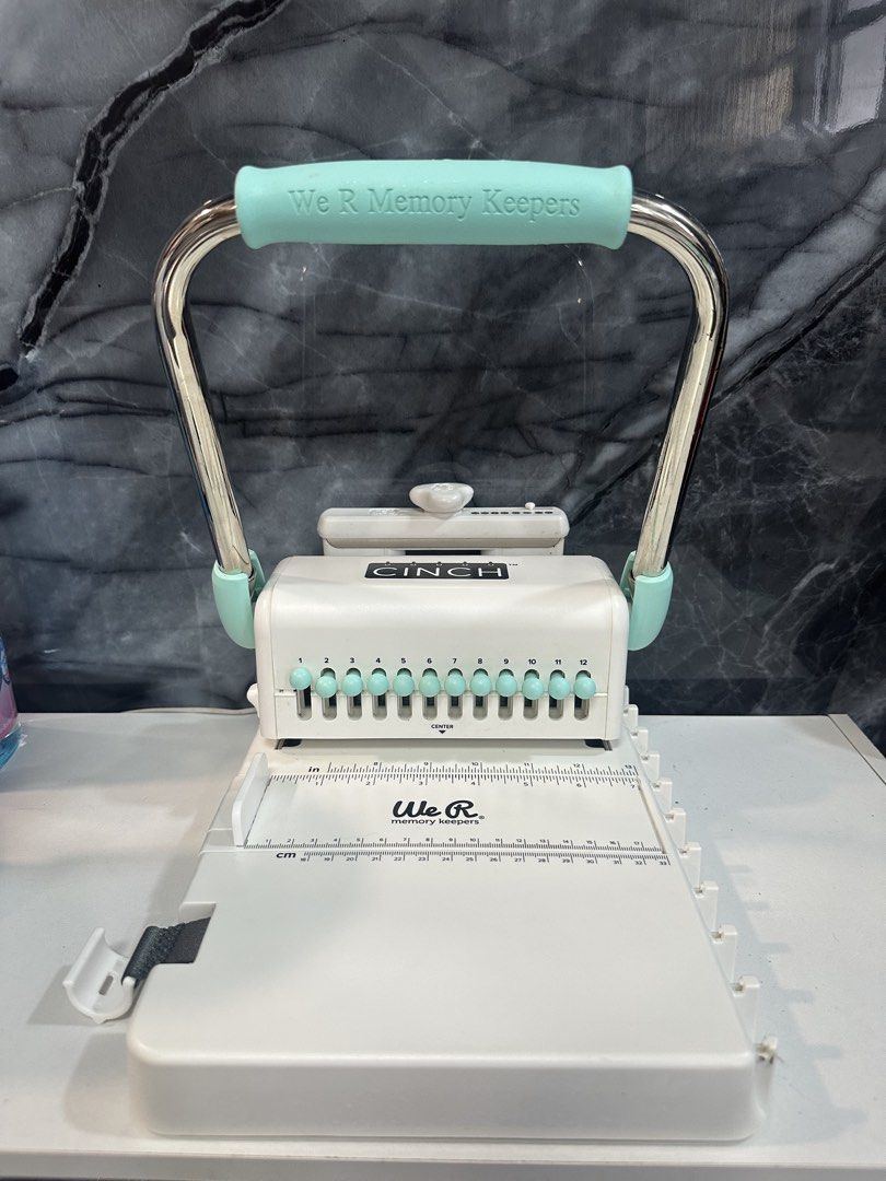 We R Memory Keepers Cinch V2 White Mint Book Binding Tool (Category: Craft Supplies & Tools) located in Lipa City. Submitted by kiangkong (Listing ID 1459171277, Image 1). Description: - We R Memory Keepers Cinch V2 book binding tool - Color: White and Mint - Create custom books and journals - Easily punch holes and bind pages - Includes original box - Ideal for crafting and scrapbooking projects.