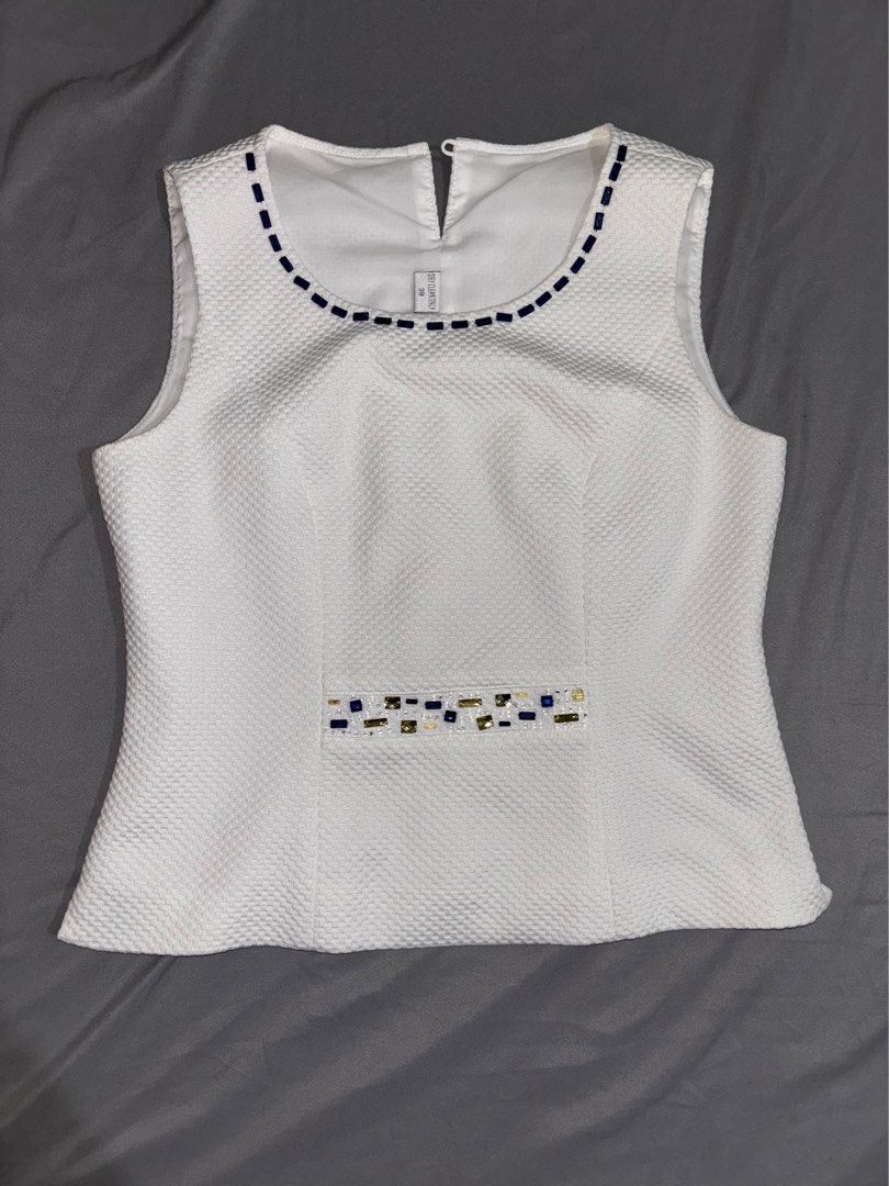 White Blouse for women (Category: Blouses) located in Manila. Submitted by alieamarie (Listing ID 1459195152, Image 1). Description: This white textured sleeveless top , a classic crew neckline trimmed with dark blue stitching and a vertical waist panel with gold and blue geometric embellishments..