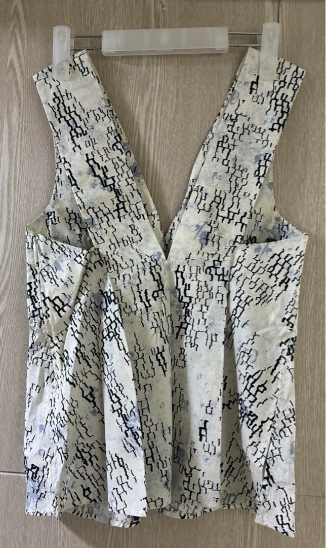White Sleeveless V-Neck Top with Abstract Print (Category: Sleeveless) located in Manila. Submitted by decluterthings888 (Listing ID 1459102247, Image 1). Description: - Sleeveless white top with a deep V-neckline. - Features a unique black and blue abstract print. - Fabric has a subtle, elegant sheen. - Flattering cut that flares slightly at the hem. - Versatile piece: dress it up or down!.
