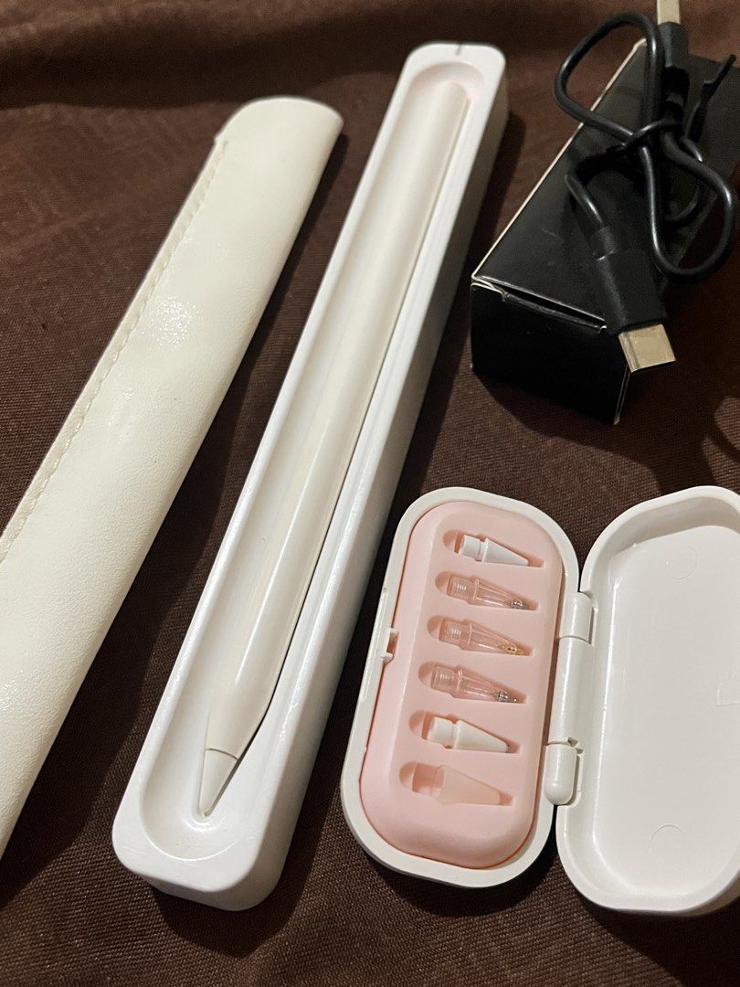 White Stylus Pen with Accessories (Category: Other Mobile & Gadget Accessories) located in Guagua. Submitted by chelsea_990 (Listing ID 1459120489, Image 2). Description: - White stylus pen - Includes charging cable and adapter - Comes with a protective case (pink interior) - Multiple replacement tips included - Pen fits snugly in its holder - Everything is clean and ready for use.