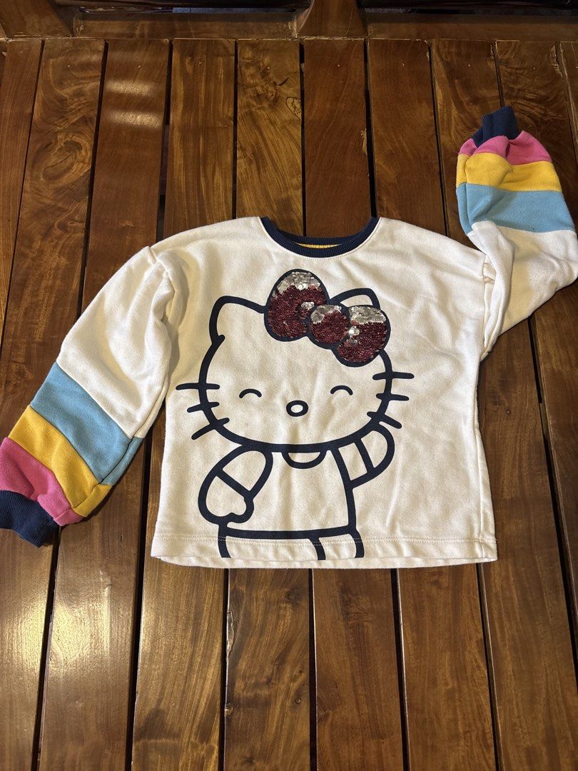 365 Kids Hello Kitty Sequin Bow Sweatshirt Rainbow Sleeve (Category: Babies & Kids Fashion) located in Manila. Submitted by wardrobeinmnl (Listing ID 1462943320, Image 1). Description: SIZE: 5 -White long-sleeve sweatshirt - Large Kitty graphic - Kitty bow with reversible red/silver sequins - Colorful rainbow stripes on sleeves - Ribbed navy blue neckline and cuffs - Made from a comfortable cotton blend - Ideal for Kitty fans.