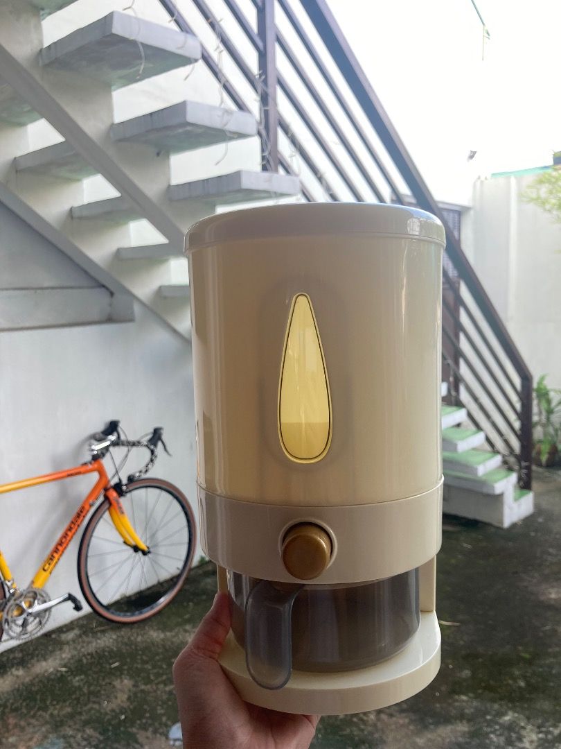 5 kg Automatic Press Type Rice Dispenser (Category: Pitchers & Dispensers) located in Manila. Submitted by ehemcoughnut (Listing ID 1462968755, Image 1). Description: - Milky white-colored rice dispenser - 5 kg capacity - Includes measuring cup with water drain - Built-in insect repellent box - Non-stick funnel design - 297 pesos from orange app RFS: decluttering.