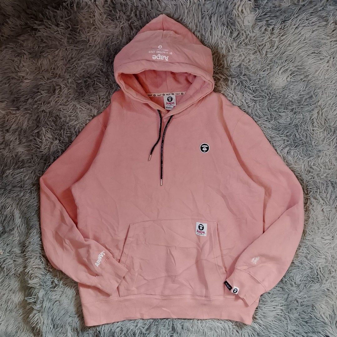 Aape by A Bathing Ape hoodie (Category: Coats, Jackets and Outerwear) located in Panabo. Submitted by sinneddasalla (Listing ID 1458216591, Image 1). Description: Aape by A Bathing Ape pullover hoodie pink Dimes: width 23 Length 27 sleeve Length 31 Hem 20 Excellent condition complete tags color rate 10/10 color may vary due to lightning 📸.
