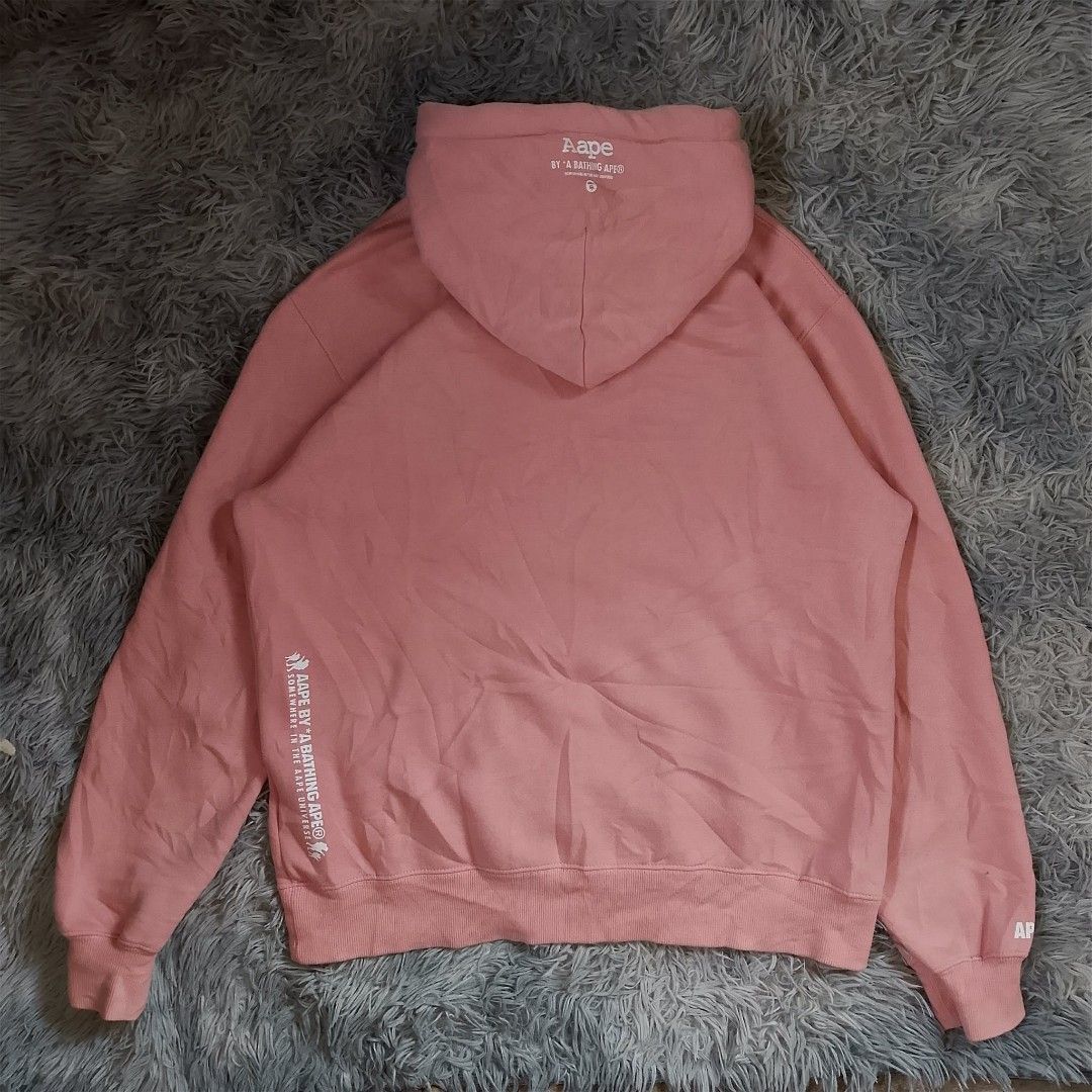 Aape by A Bathing Ape hoodie (Category: Coats, Jackets and Outerwear) located in Panabo. Submitted by sinneddasalla (Listing ID 1458216591, Image 2). Description: Aape by A Bathing Ape pullover hoodie pink Dimes: width 23 Length 27 sleeve Length 31 Hem 20 Excellent condition complete tags color rate 10/10 color may vary due to lightning 📸.