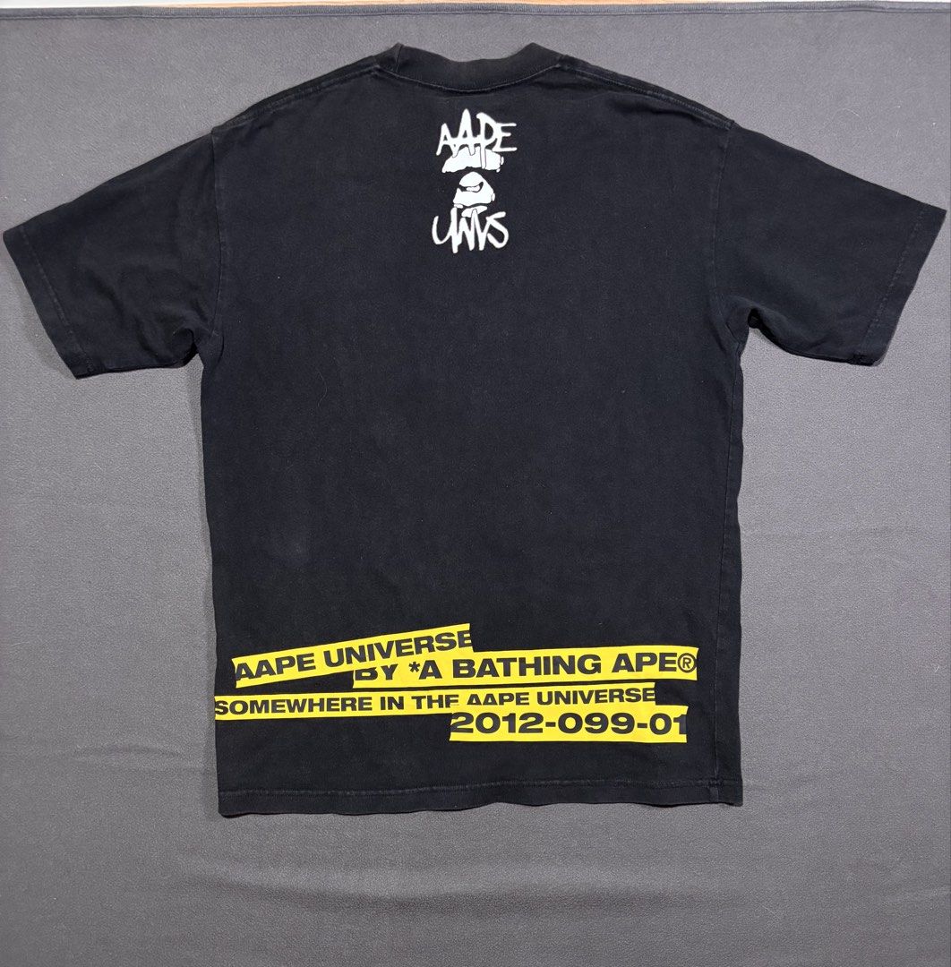 AAPE by A Bathing Ape Universe Graphic Tee (Category: Tshirts & Polo Shirts ) located in Mabalacat. Submitted by _limitlessfashion (Listing ID 1462897891, Image 3). Description: - Black AAPE Universe graphic t-shirt - Guaranteed authentic - Length 27.5 - Width 21 - Color rate & condition 9/10 - Minimal hairlines on front print - Features a cool ape graphic with 'AAPE UNVS' text on the front - Back has 'AAPE UNIVERSE' text with yellow tape detail 