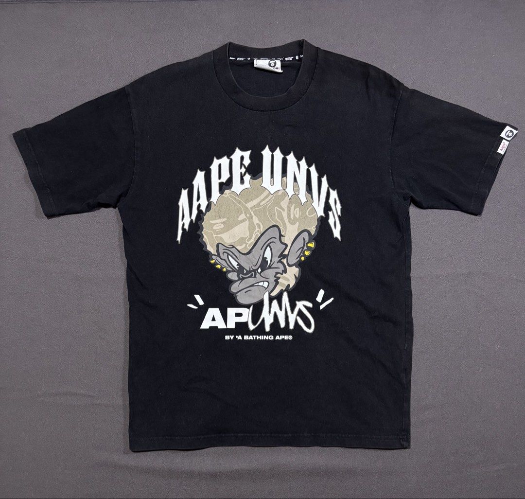 AAPE by A Bathing Ape Universe Graphic Tee (Category: Tshirts & Polo Shirts ) located in Mabalacat. Submitted by _limitlessfashion (Listing ID 1462897891, Image 1). Description: - Black AAPE Universe graphic t-shirt - Guaranteed authentic - Length 27.5 - Width 21 - Color rate & condition 9/10 - Minimal hairlines on front print - Features a cool ape graphic with 'AAPE UNVS' text on the front - Back has 'AAPE UNIVERSE' text with yellow tape detail 