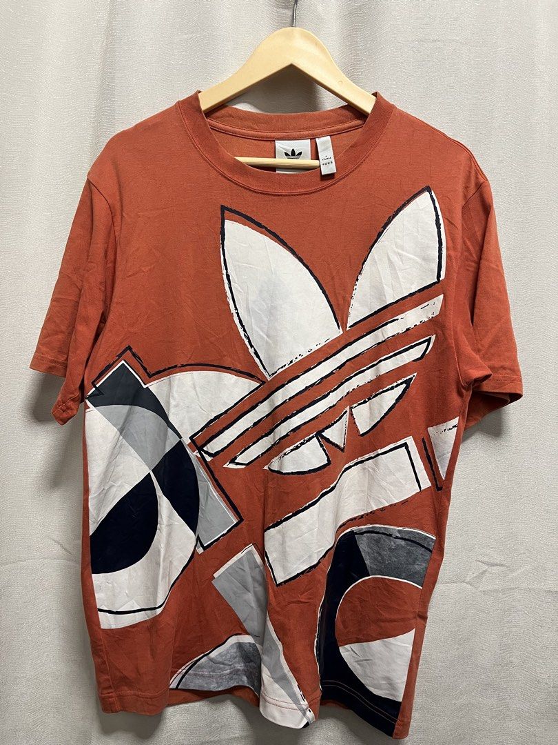 Adidas Graphic T-Shirt Orange (Category: Tshirts & Polo Shirts ) located in Davao. Submitted by znerol_26 (Listing ID 1462975461, Image 1). Description: - Orange Adidas T-shirt - Features bold graphic print with classic Adidas trefoil logo - Made in China - Size S (175/92A) - Ideal for casual wear.