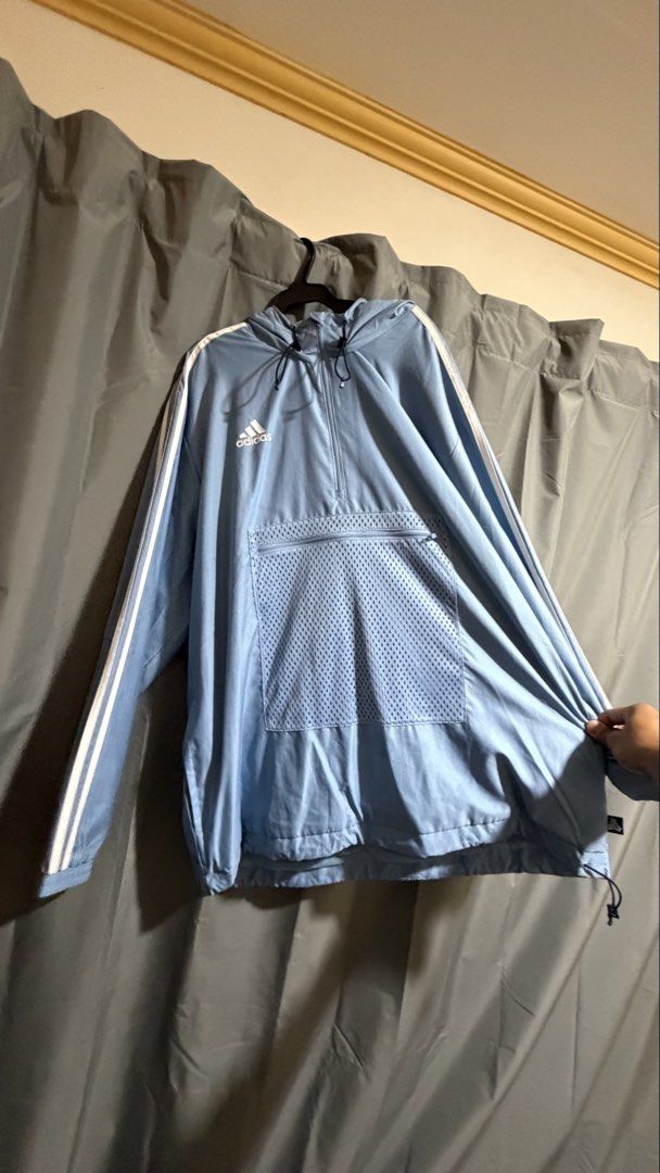 Adidas Light Blue Windbreaker Jacket (Category: Coats, Jackets and Outerwear) located in Manila. Submitted by sneakspxxks (Listing ID 1463028707, Image 1). Description: - Light blue Adidas windbreaker jacket - Classic three stripes on sleeves - Large front pocket with mesh detail and zip closure - Half-zip neckline with hood - Drawstring at the hem - Ideal for casual wear or sports.