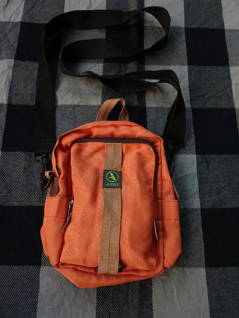 Aigle Orange Crossbody Bag (Category: Cross-body Bags) located in Manila. Submitted by timog_high_ice_v2 (Listing ID 1463115348, Image 1). Description: - Orange Aigle crossbody bag - Main zip compartment - Front pocket - Adjustable strap - Small top handle - Durable material - Aigle logo zipper pull - Ideal for everyday use.