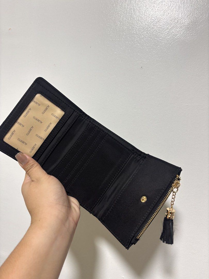 ALBERTO Black Tri-fold Wallet with Tassel Charm (Category: Wallets & Card holders) located in Guiguinto. Submitted by 2nd.stuff. (Listing ID 1462909253, Image 2). Description: - Cute black tri-fold wallet by ALBERTO - Exterior zip pocket with tassel charm - Interior card slots and clear ID window - ALBERTO logo lining - Compact and practical for everyday use.