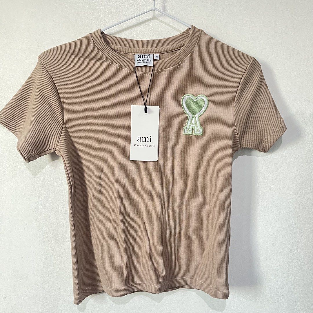 AMI Paris Ribbed T-Shirt (Category: Shirts) located in Quezon City. Submitted by shopnina (Listing ID 1462983405, Image 1). Description: - Brand: AMI Paris - Color: Beige - Style: Ribbed T-shirt - Logo: Signature Ami de Coeur patch on chest - Material: 100% Organic Cotton - Size: Medium (M) - Condition: Brand new with original tags - Perfect for: Casual wear, everyday styling -bought online over…ns RFS: decluttering.