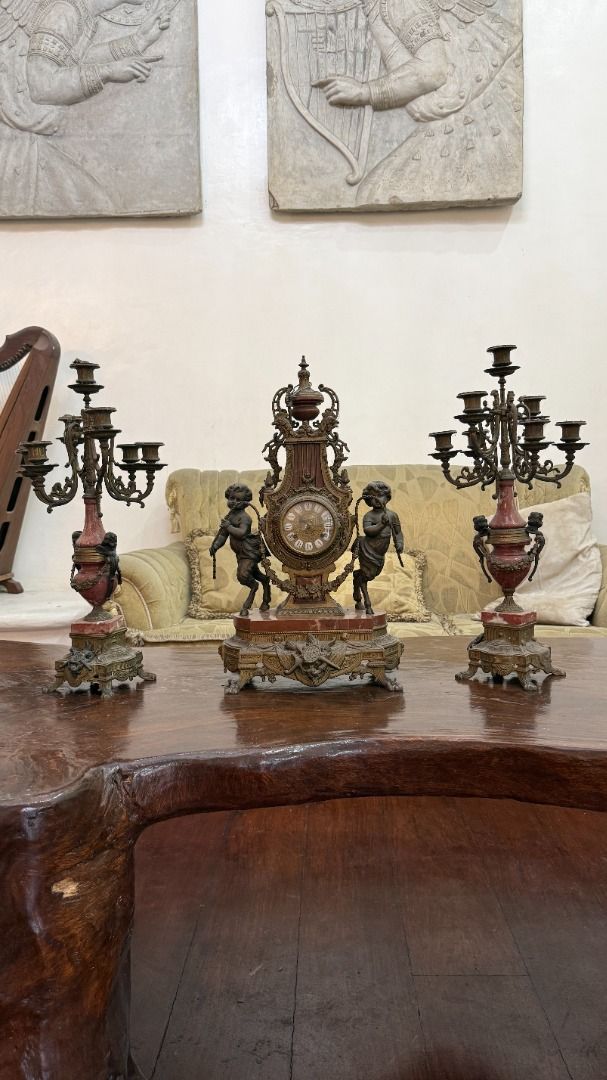 Antique mantel clock garniture set (Category: Clocks) located in Cainta. Submitted by caroldy10 (Listing ID 1462952240, Image 1). Description: Ornate vintage Italian mantel clock with candelabras set A mid-20th-century garniture set featuring cast metal or brass with marble accents and flanking cherub figures. This specific design is a mid-to-late 20th-century Imperial / Brevettato model made in Italy, often fitted with German movements by Franz 