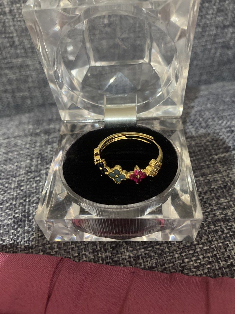 Assorted Gemstone Ring with Gold Band (Category: Rings) located in Valenzuela. Submitted by theaveqc04360 (Listing ID 1463033674, Image 1). Description: - Gold band ring - Features colorful gemstones: blue, green, and pink - Unique floral-inspired design - Versatile: great for stacking or wearing alone - Includes a clear display box.