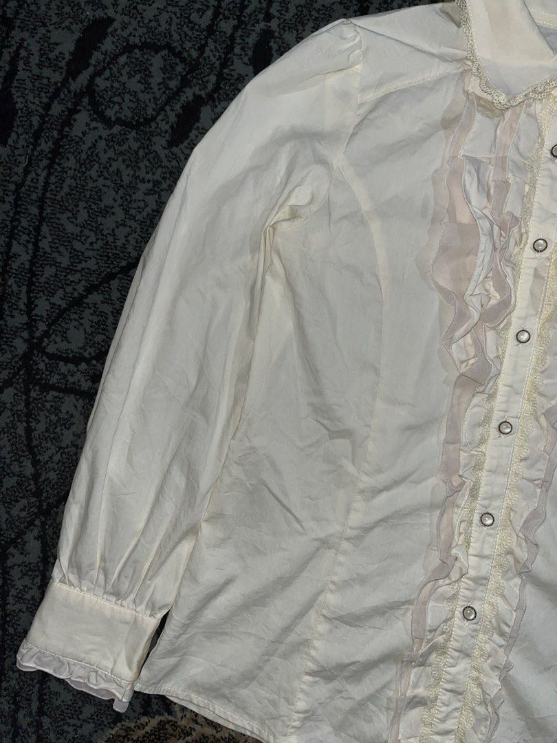 Axes Femme Ruffles & Laced (Category: Longsleeves) located in Manila. Submitted by kashjulliane (Listing ID 1462975726, Image 3). Description: This is an ivory long-sleeve blouse by axes femme featuring delicate front ruffles and a lace-trimmed collar. Excellent condition Good as new High quality Made in Japan Deadstock/Vintage Width: 17 Length: 23 Sleeves: 21.5.