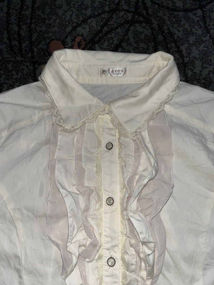 Axes Femme Ruffles & Laced (Category: Longsleeves) located in Manila. Submitted by kashjulliane (Listing ID 1462975726, Image 2). Description: This is an ivory long-sleeve blouse by axes femme featuring delicate front ruffles and a lace-trimmed collar. Excellent condition Good as new High quality Made in Japan Deadstock/Vintage Width: 17 Length: 23 Sleeves: 21.5.