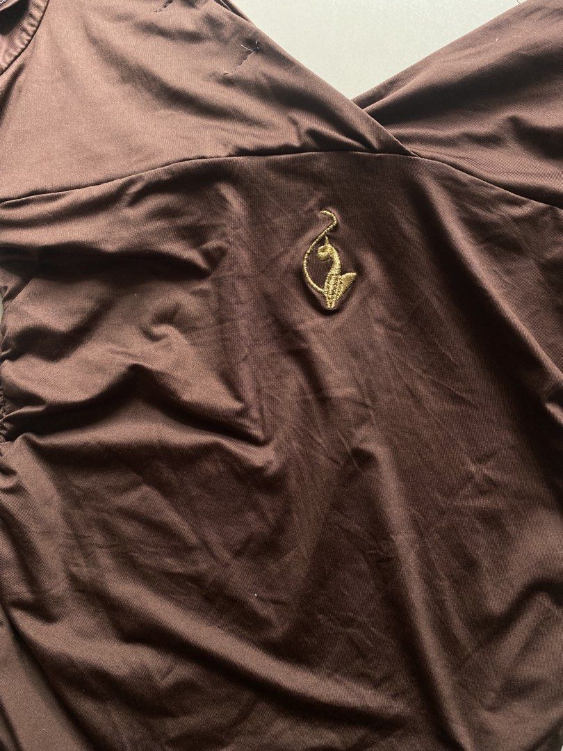 Baby Phat Brown Ruched Off-Shoulder Top (Category: Blouses) located in Tulunan. Submitted by pochi___trift (Listing ID 1462964004, Image 3). Description: - Brand: Baby Phat - Color: Brown - Style: Off-shoulder top - Features: Ruched sides, crossover neckline, flutter sleeves - Detail: Embroidered Baby Phat logo on front - Occasion: Great for night outs or casual wear.
