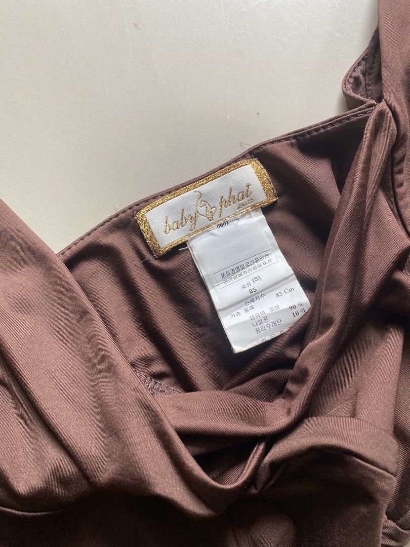 Baby Phat Brown Ruched Off-Shoulder Top (Category: Blouses) located in Tulunan. Submitted by pochi___trift (Listing ID 1462964004, Image 2). Description: - Brand: Baby Phat - Color: Brown - Style: Off-shoulder top - Features: Ruched sides, crossover neckline, flutter sleeves - Detail: Embroidered Baby Phat logo on front - Occasion: Great for night outs or casual wear.