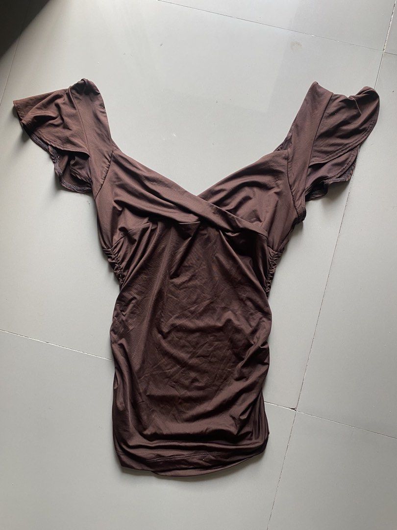 Baby Phat Brown Ruched Off-Shoulder Top (Category: Blouses) located in Tulunan. Submitted by pochi___trift (Listing ID 1462964004, Image 1). Description: - Brand: Baby Phat - Color: Brown - Style: Off-shoulder top - Features: Ruched sides, crossover neckline, flutter sleeves - Detail: Embroidered Baby Phat logo on front - Occasion: Great for night outs or casual wear.