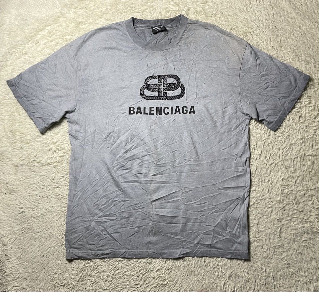 Balenciaga BB Interlock Logo Distressed T-shirt (Category: Tshirts & Polo Shirts ) located in Matanao. Submitted by jikeserran00389 (Listing ID 1462922713, Image 1). Description: This is a grey Balenciaga BB Interlock Logo T-shirt featuring a distressed crewneck and a textured black logo graphic across the chest. 23x30 Excellent Condition Complete tags.