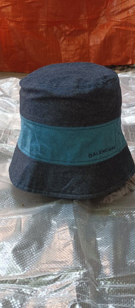 Balenciaga Paris Denim Bucket Hat (Category: Hats & Beanies) located in Quezon City. Submitted by mangthrift (Listing ID 1463039010, Image 1). Description: - Balenciaga Paris bucket hat - Dark denim with a teal band - Balenciaga logo detail on the band - Size: 57cm Adult - Made in Korea - Condition: Good.