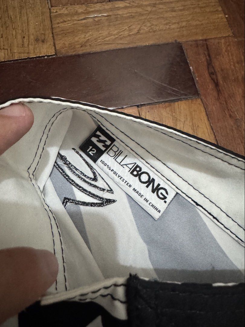 Billabong Board Shorts (Category: Shorts) located in Manila. Submitted by mabuhaymiles (Listing ID 1463037684, Image 2). Description: - Brand: Billabong - Size: 12 - Design: Black and white tribal print with gold accents - Material: 100% Polyester - Closure: Lace-up front - Features: Back pocket with velcro closure - Ideal for: Swimming, surfing, or beach activities.