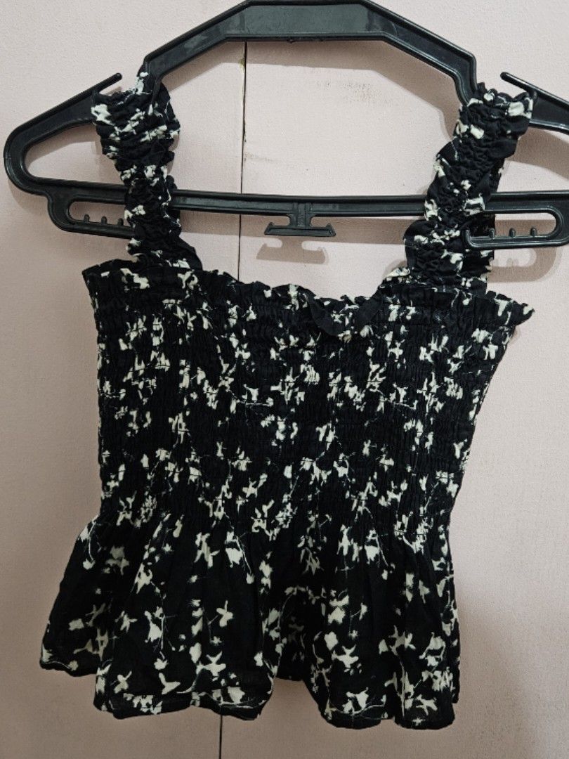 Black floral smocked crop top (Category: Sleeveless) located in Quezon City. Submitted by jeannego (Listing ID 1462951701, Image 1). Description: - Cute black crop top - White floral print - Smocked design for a stretchy and comfortable fit - Short, ruffled sleeves - Versatile: pairs well with high-waisted jeans or skirts - Ideal for casual outings.