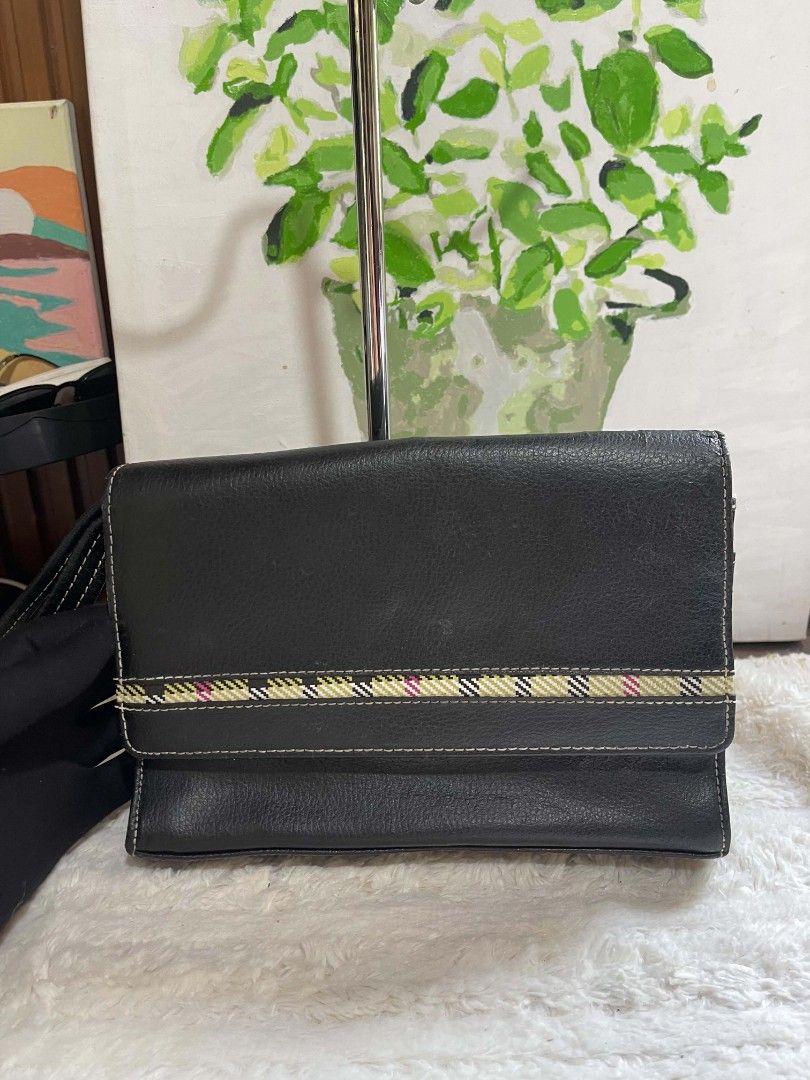 Black Leather Clutch Bag with Plaid Accent (Category: Belt bags, Clutches and Pouches) located in Naawan. Submitted by twilly.apparel2 (Listing ID 1462917759, Image 1). Description: - issue crack sa leather sa loob and sa labas Sleek black leather clutch - Elegant plaid ribbon accent on the front - Classic white stitching detail throughout - Convenient small wrist strap included - Secure side zipper closure - Measures approximately 8 inches wide.