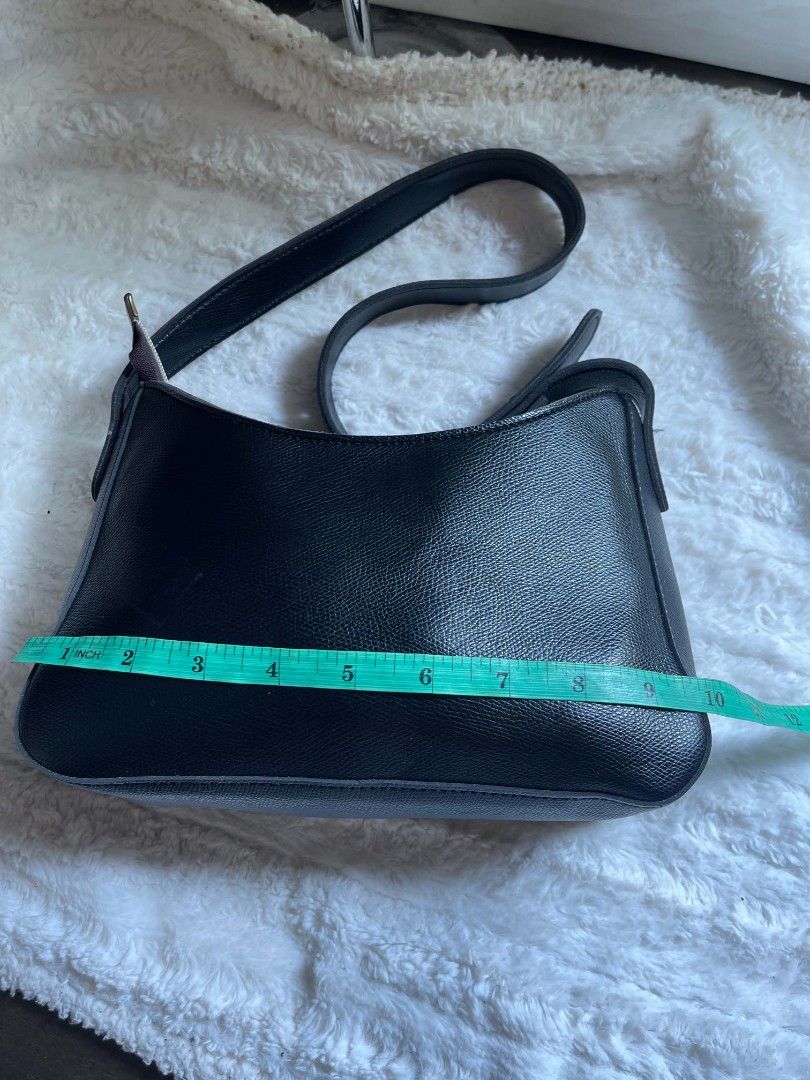 Black Leather Shoulder Bag (Category: Shoulder Bags) located in Naawan. Submitted by twilly.apparel2 (Listing ID 1462902944, Image 3). Description: - Classic black leather shoulder bag - Textured leather finish - Secure zipper closure - Adjustable strap with buckle details - Versatile and simple design - Ideal for everyday use - Approximately 10 inches wide.