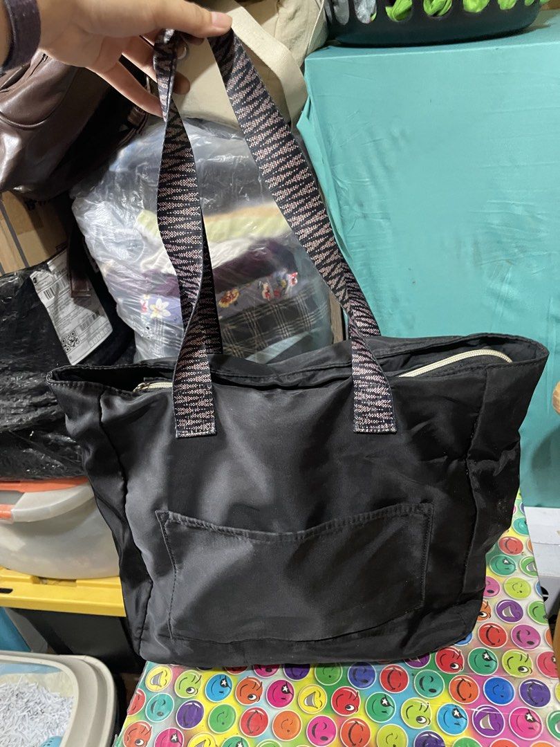 Black Tote Bag with Patterned Straps (Category: Tote Bags) located in Quezon City. Submitted by garagesaleonline (Listing ID 1462892073, Image 1). Description: - Classic black tote bag - Convenient front pocket - Unique zigzag patterned straps - Secure top zipper closure - Spacious interior for all your essentials - Ideal for everyday use.
