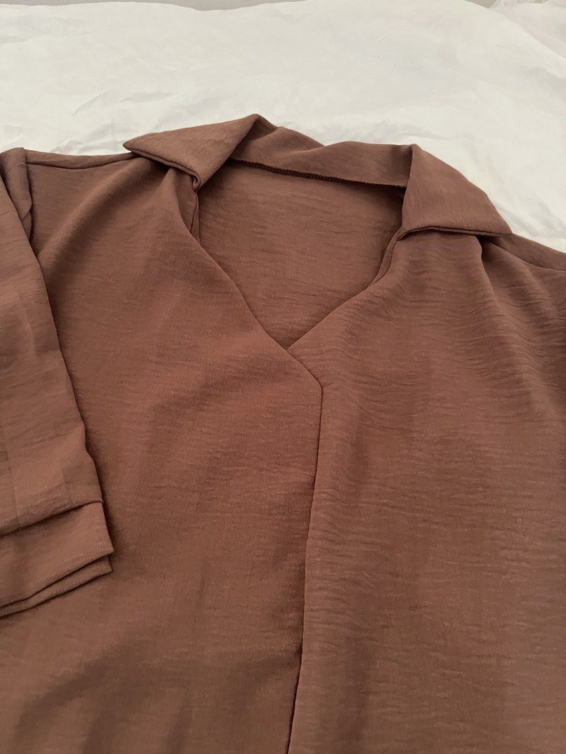 Brown Collared V-Neck 3/4 Sleeve Blouse (Category: Blouses) located in Manila. Submitted by happydani (Listing ID 1462957015, Image 2). Description: - Stylish brown blouse - Textured crinkle fabric - Collared V-neck design - 3/4 sleeves with folded cuffs - Relaxed fit for comfort - Versatile for casual or work outfits - can fit upto 34B.