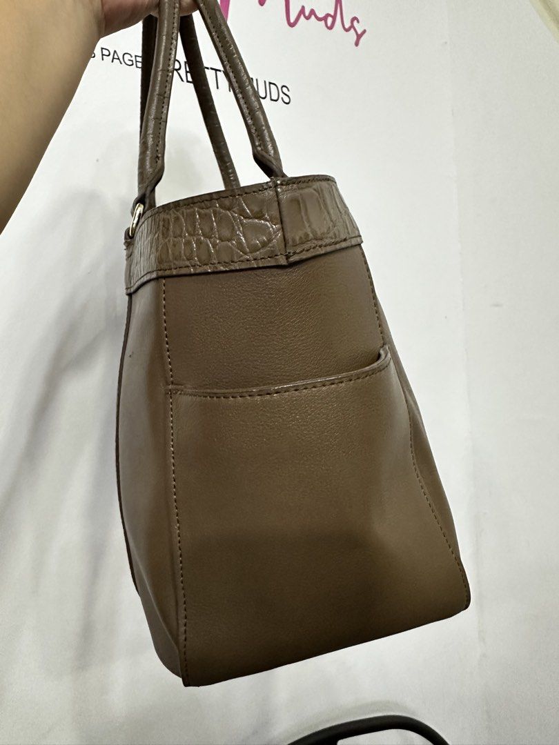 Brown Leather Tote Bag with Crocodile Trim (Category: Tote Bags) located in Cardona. Submitted by jaxdelossa10453 (Listing ID 1463012462, Image 2). Description: - Classic brown leather tote bag - Crocodile embossed trim on top and sides - Two convenient exterior pockets - Vibrant red fabric interior lining - Secure zipper closure with gold-tone pull - Spacious for daily essentials - Ideal for work or casual use.