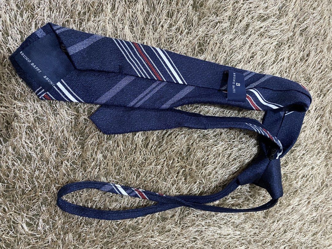 Bruno Baffi Navy Blue Plaid Tie (Category: Ties) located in Bulacan. Submitted by rich2545 (Listing ID 1462905572, Image 3). Description: - Brand: Bruno Baffi - Color: Navy blue - Pattern: Plaid with white and red stripes - Accent: Small metal emblem on the front - Style: Suitable for both formal and casual wear.