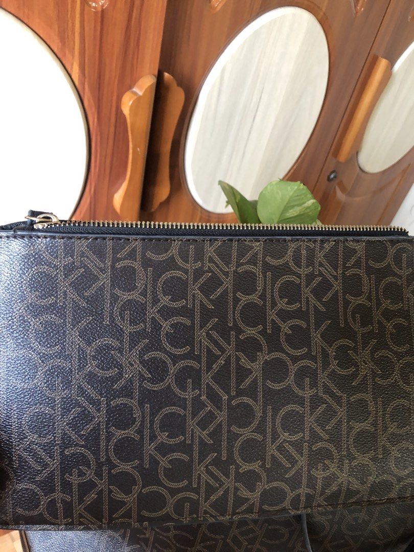 Calvin Klein Monogram Tote Bag with Pouch (Category: Luxury Bags & Wallets) located in Makati City. Submitted by mitchi_koy28 (Listing ID 1462950279, Image 2). Description: - Brown Calvin Klein tote bag - All-over CK monogram print - Includes matching zippered pouch - Gold tone hardware - Interior zippered pockets - Ideal for everyday use or travel - Received as a gift.