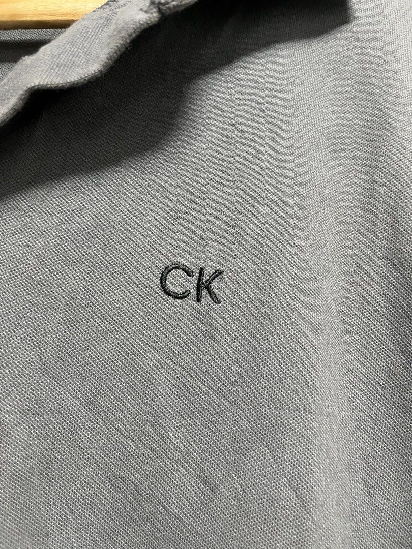 Calvin Klein Performance Grey Polo Shirt Size L (Category: Tshirts & Polo Shirts ) located in Davao. Submitted by znerol_26 (Listing ID 1462972263, Image 2). Description: - Grey Calvin Klein Performance polo shirt - Size: L - Features embroidered CK logo on the chest - Made in Vietnam - Ideal for casual wear or sports activities.