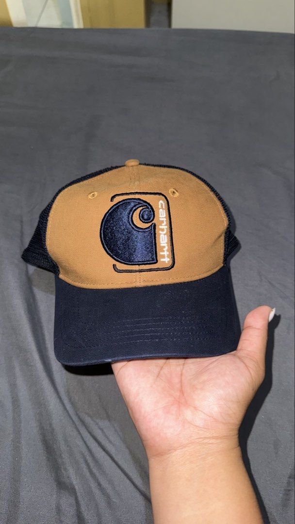 Carhartt Trucker Cap - Brown, Navy, Mesh Back (Category: Caps & Hats) located in Manila. Submitted by nobleangel (Listing ID 1462921436, Image 1). Description: - Classic Carhartt trucker cap - Brown front panels with navy brim and mesh back - Features iconic Carhartt logo patch on the front - Adjustable snapback for a comfortable, custom fit - Ideal for everyday style and sun protection.