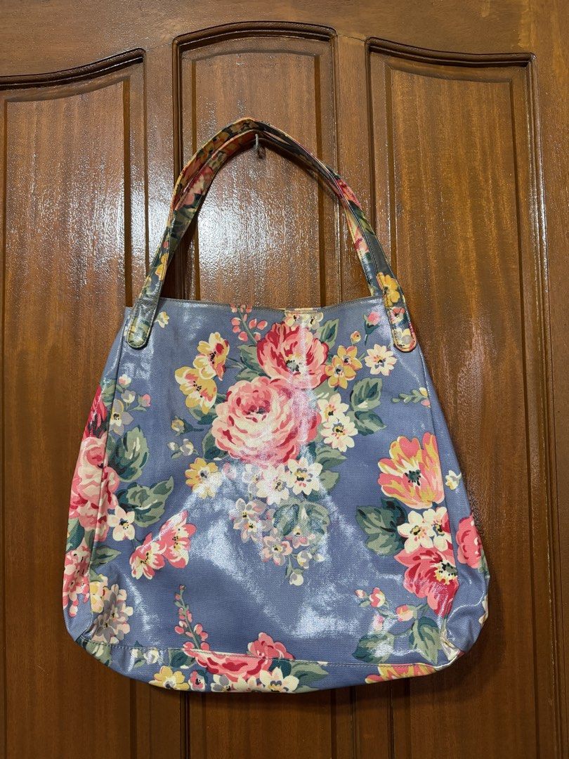 Cath Kidston Floral Tote Bag (Category: Tote Bags) located in Manila. Submitted by prelovedbylkt (Listing ID 1463031451, Image 2). Description: - Brand: Cath Kidston - Style: Floral Tote Bag - Color: Blue base with vibrant floral print - Interior: Pink polka dot lining with multiple pockets - Closure: Button at the top - Ideal for: Everyday use, travel bag - Issue: Stains on exterior .
