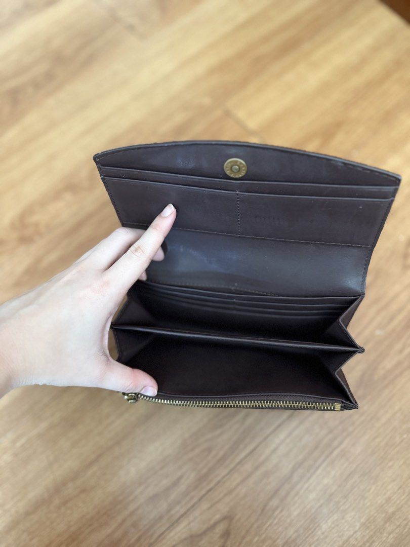 Charles & Keith Brown Leather Long Wallet (Category: Wallets & Card holders) located in Muntinlupa City. Submitted by stephschrber (Listing ID 1462946741, Image 3). Description: - Brand: Charles & Keith - Material: Brown Leather - Closure: Snap Button - Interior: Multiple card slots, zippered coin compartment - Condition: Spacious with a clean interior.