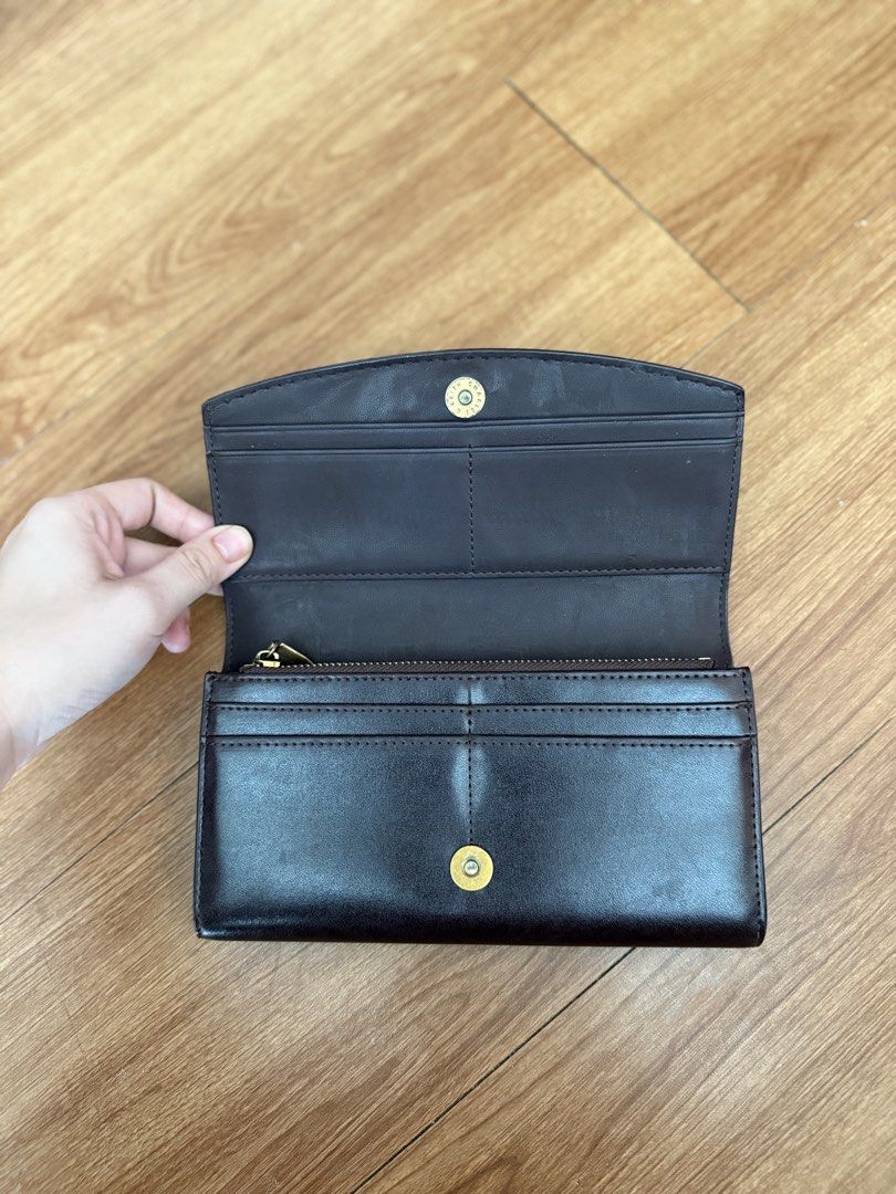 Charles & Keith Brown Leather Long Wallet (Category: Wallets & Card holders) located in Muntinlupa City. Submitted by stephschrber (Listing ID 1462946741, Image 2). Description: - Brand: Charles & Keith - Material: Brown Leather - Closure: Snap Button - Interior: Multiple card slots, zippered coin compartment - Condition: Spacious with a clean interior.