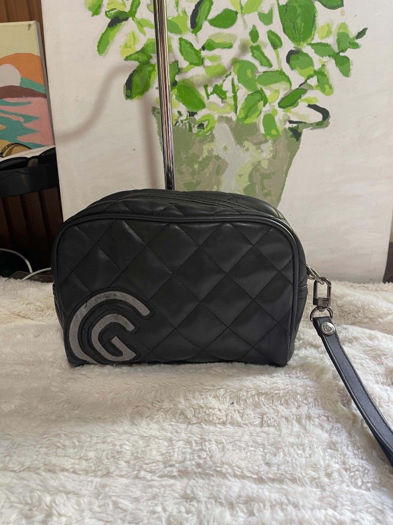 Cleveland Quilted Cosmetic Bag Pouch (Category: Purses & Pouches) located in Naawan. Submitted by twilly.apparel2 (Listing ID 1462950232, Image 1). Description: - Black quilted cosmetic bag from Cleveland - Features a large 'G' logo on the front - Secure zipper closure - Includes a convenient wrist strap - Dimensions: Approximately 9 inches long and 4 inches tall - Ideal for travel or everyday organization.