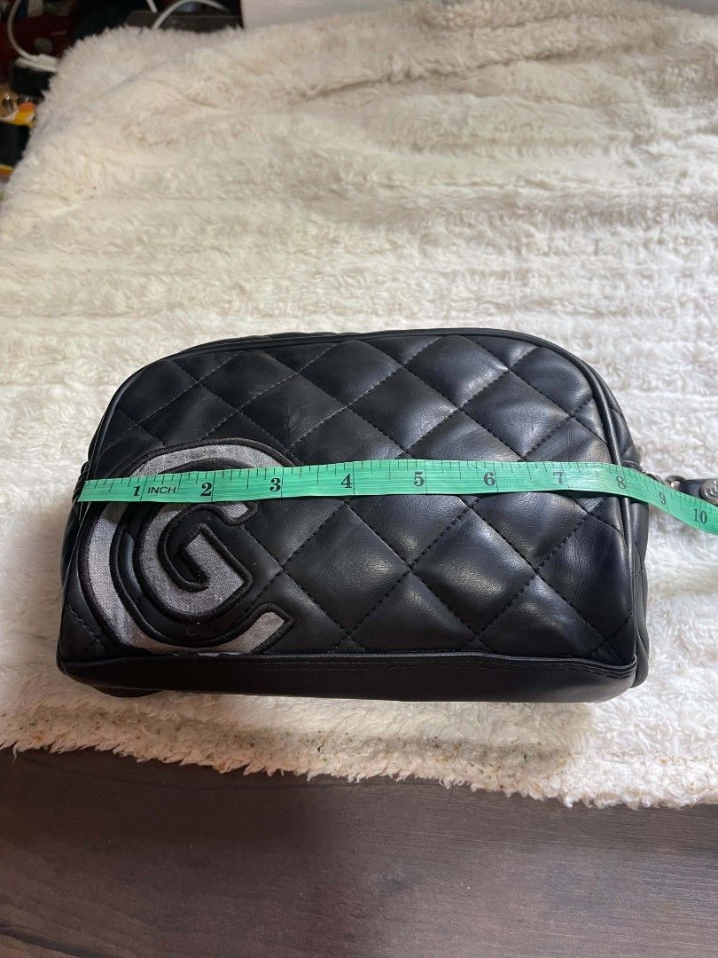 Cleveland Quilted Cosmetic Bag Pouch (Category: Purses & Pouches) located in Naawan. Submitted by twilly.apparel2 (Listing ID 1462950232, Image 2). Description: - Black quilted cosmetic bag from Cleveland - Features a large 'G' logo on the front - Secure zipper closure - Includes a convenient wrist strap - Dimensions: Approximately 9 inches long and 4 inches tall - Ideal for travel or everyday organization.