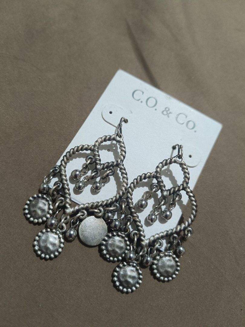 C.O. & Co. Silver Dangle Earrings with Charms (Category: Earrings) located in Bacolod City. Submitted by jewels.of.joy (Listing ID 1462998344, Image 1). Description: - Brand: C.O. & Co. - Material: Silver tone - Design: Twisted heart shape with multiple small dangling charms - Style: Cute, adds flair to any outfit - Occasion: Perfect for casual wear or dressing up.