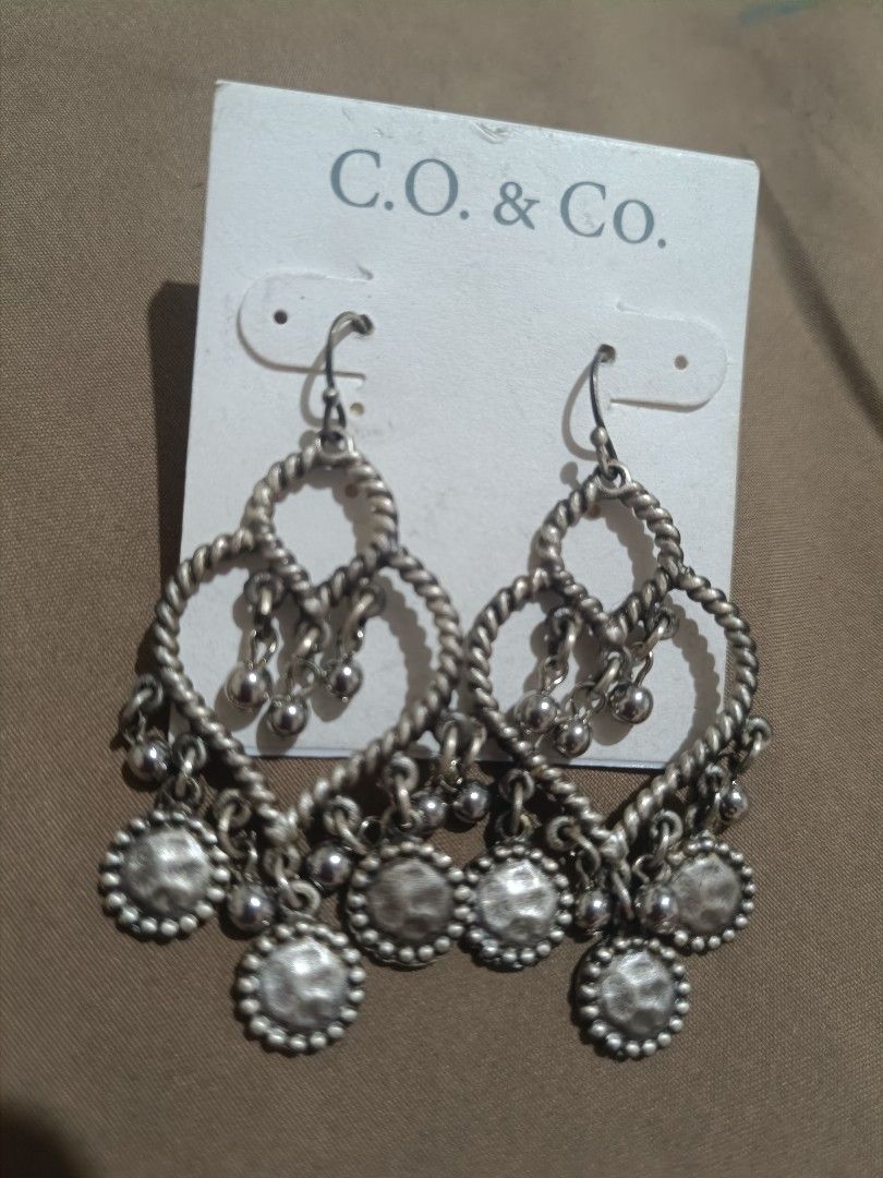 C.O. & Co. Silver Dangle Earrings with Charms (Category: Earrings) located in Bacolod City. Submitted by jewels.of.joy (Listing ID 1462998344, Image 2). Description: - Brand: C.O. & Co. - Material: Silver tone - Design: Twisted heart shape with multiple small dangling charms - Style: Cute, adds flair to any outfit - Occasion: Perfect for casual wear or dressing up.