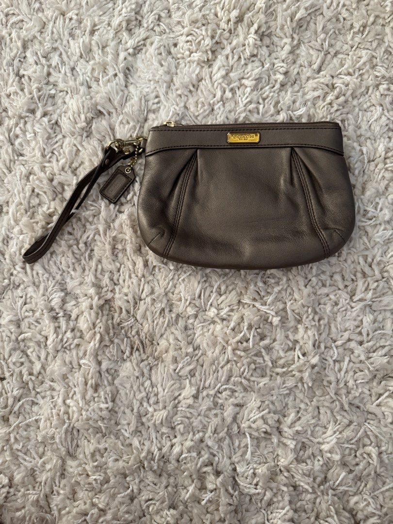 Coach Metallic Brown Leather Wristlet Pouch (Category: Purses & Pouches) located in San Nicolas. Submitted by ihascat (Listing ID 1462950166, Image 1). Description: - Authentic Coach wristlet in metallic brown leather - Elegant pleated detail on the front - Includes a detachable wrist strap - Authentic Coach tag attached - Secure zipper closure - Ideal for carrying your daily essentials.