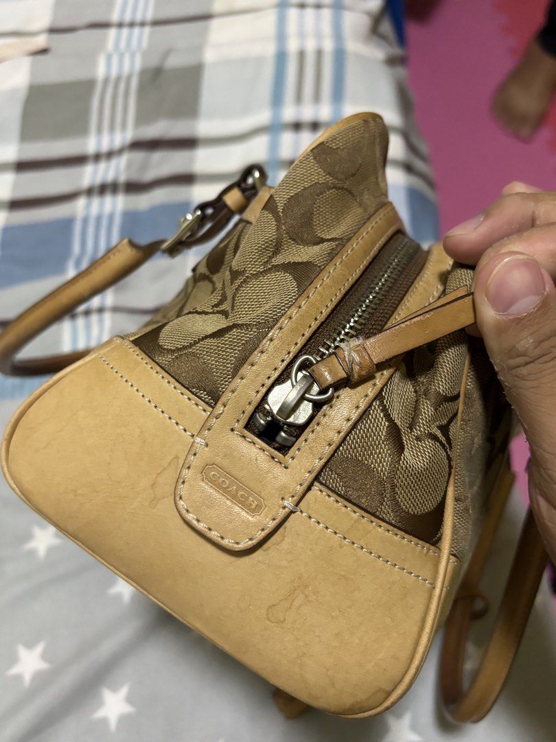 Coach Monogram Canvas Leather Trimmed Handbag (Category: Luxury Bags & Wallets) located in Silang. Submitted by lakasthrift1577 (Listing ID 1463021949, Image 3). Description: - Classic Coach monogram canvas handbag - Tan leather trim and handles - Secure top zipper closure - Charming small tassel detail on the side - Interior tag with serial number N° B06W-8K05 - A timeless and versatile piece No issue .