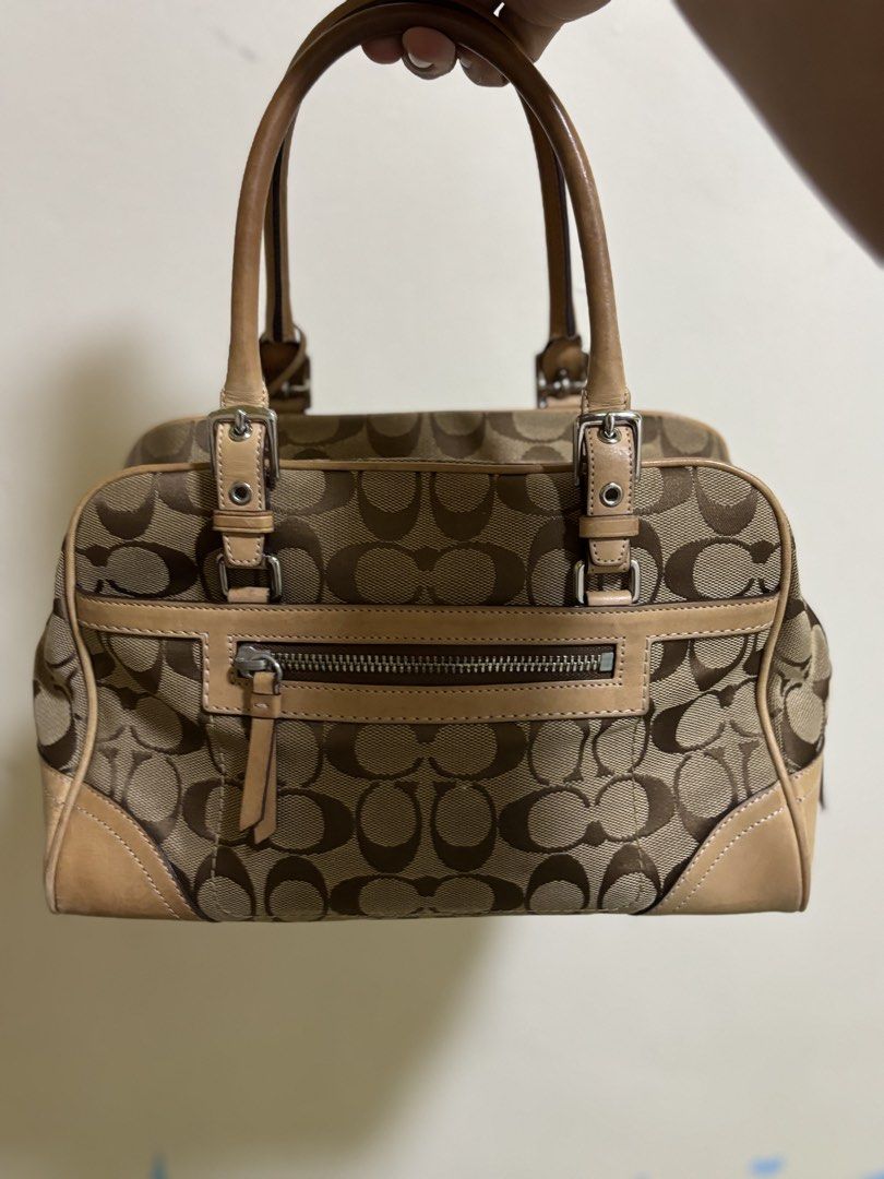 Coach Monogram Canvas Leather Trimmed Handbag (Category: Luxury Bags & Wallets) located in Silang. Submitted by lakasthrift1577 (Listing ID 1463021949, Image 2). Description: - Classic Coach monogram canvas handbag - Tan leather trim and handles - Secure top zipper closure - Charming small tassel detail on the side - Interior tag with serial number N° B06W-8K05 - A timeless and versatile piece No issue .
