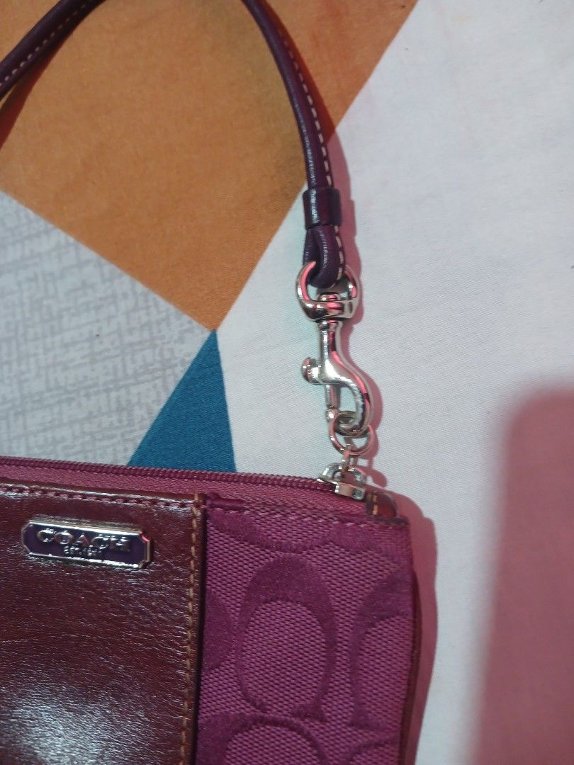 Coach Signature C Monogram Wristlet Pouch (Category: Luxury Bags & Wallets) located in Marikina City. Submitted by laila15 (Listing ID 1462915351, Image 2). Description: - Authentic Coach wristlet - Classic 'C' monogram pattern - Deep purple/magenta color - Leather trim and strap - Zipper closure - Compact size for essentials - Ideal for errands or nights out.