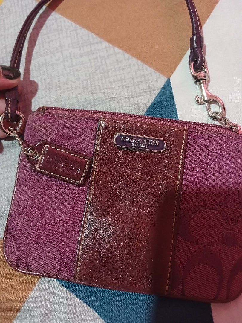 Coach Signature C Monogram Wristlet Pouch (Category: Luxury Bags & Wallets) located in Marikina City. Submitted by laila15 (Listing ID 1462915351, Image 3). Description: - Authentic Coach wristlet - Classic 'C' monogram pattern - Deep purple/magenta color - Leather trim and strap - Zipper closure - Compact size for essentials - Ideal for errands or nights out.