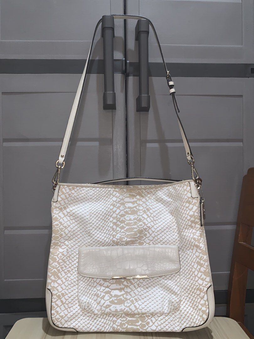 Coach Snakeskin Embossed Leather Shoulder Bag (Category: Luxury Bags & Wallets) located in Manila. Submitted by jo.arban (Listing ID 1462897870, Image 1). Description: - Stylish white and tan snakeskin embossed leather shoulder bag. - Front pocket with a sophisticated croc-embossed flap. - Elegant silver hardware details throughout. - Comfortable adjustable shoulder strap for a custom fit. - Ample interior space for all your essentials. - Your pe