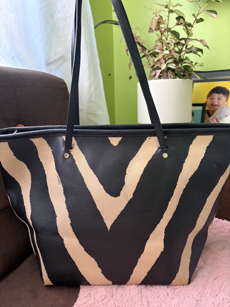 Coach Zebra Print Tote Bag (Category: Tote Bags) located in Saravia. Submitted by clynlyn (Listing ID 1462962284, Image 2). Description: - Stylish Coach tote bag with a cool zebra print. - Classic black and tan color combination. - Made from genuine leather for durability and a premium feel. - Secure top zipper closure to keep your belongings safe. - Features interior pockets for easy organization. - Includes the iconic Coach hang tag. - Ideal fo