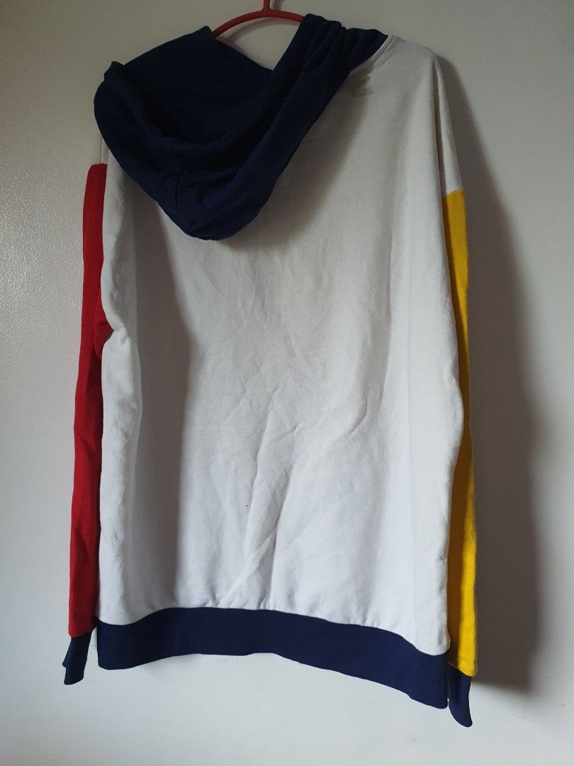 Colorblock Hoodie with Drawstrings (Category: Hoodies) located in Meycauayan. Submitted by shoptoown (Listing ID 1462941038, Image 2). Description: - White hoodie with vibrant red, blue, and yellow colorblock details on sleeves. - Features a convenient front pocket for essentials. - Adjustable yellow drawstrings for a customized fit. - Approximate measurements: Length 26 inches, Width 24 inches. - Note: Small stain on the back, washable, clearly 